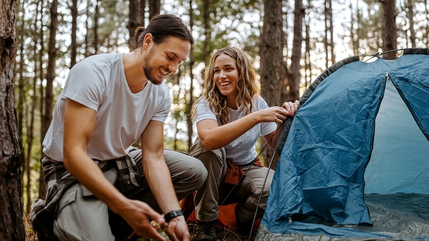 A couple setting up a tent