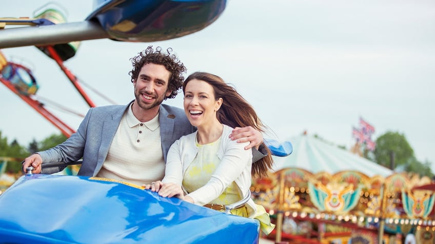 A happy couple on a ride at the amusement park