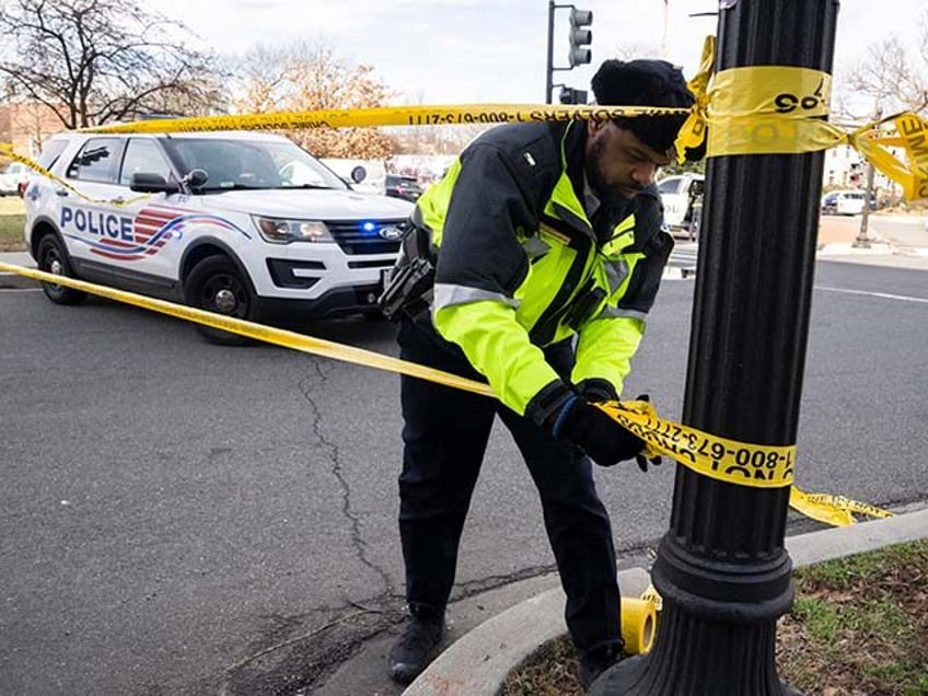 A Washington Metropolitan Police officer, puts yellow tape around the Potomac Avenue Metro