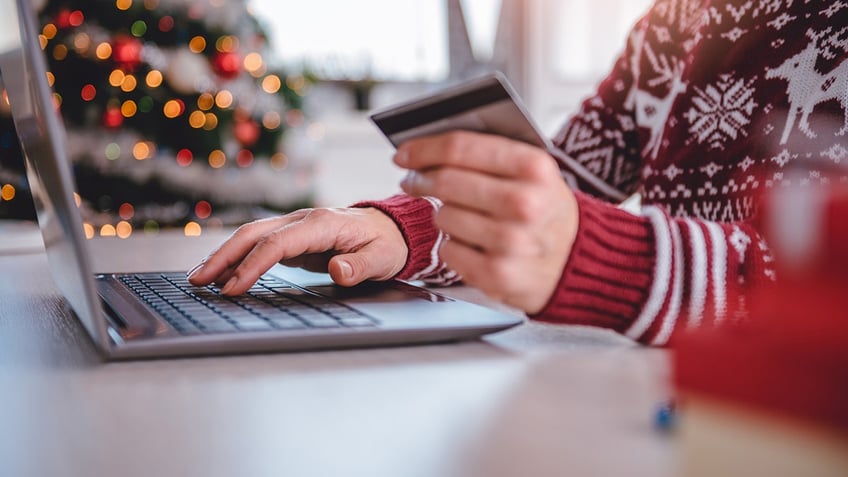 person using a laptop with a Christmas tree in the background