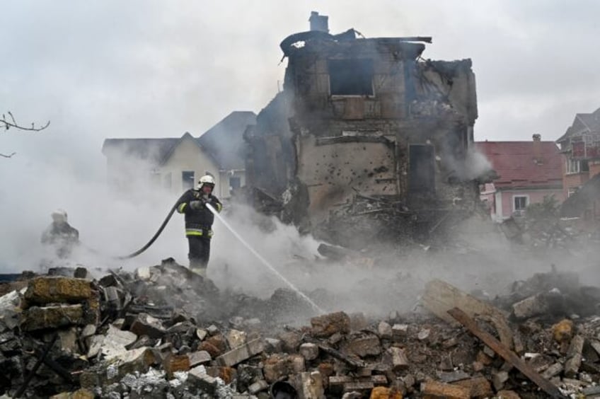 Ukrainian firefighters extinguish a blaze at houses damaged during a Russian strike on the