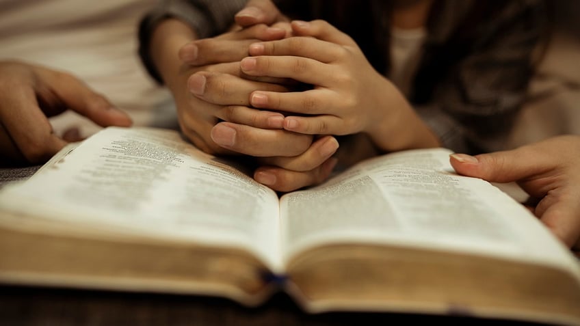 child reading Bible with adult