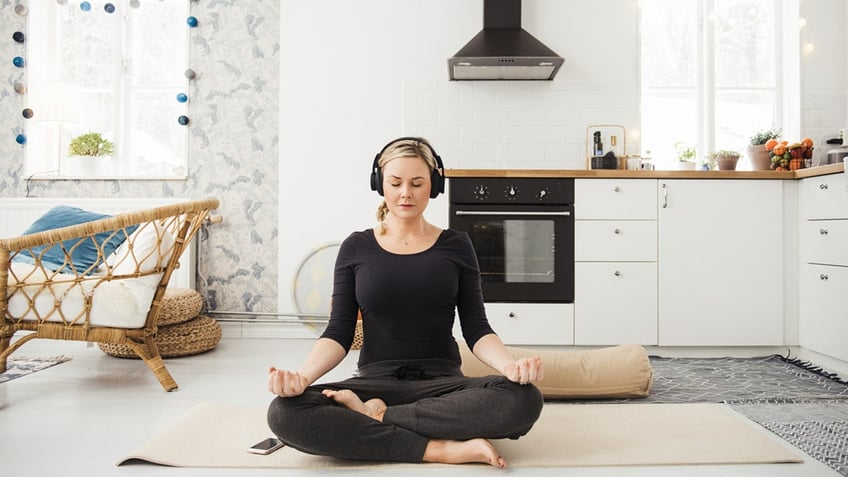 Woman meditating in kitchen