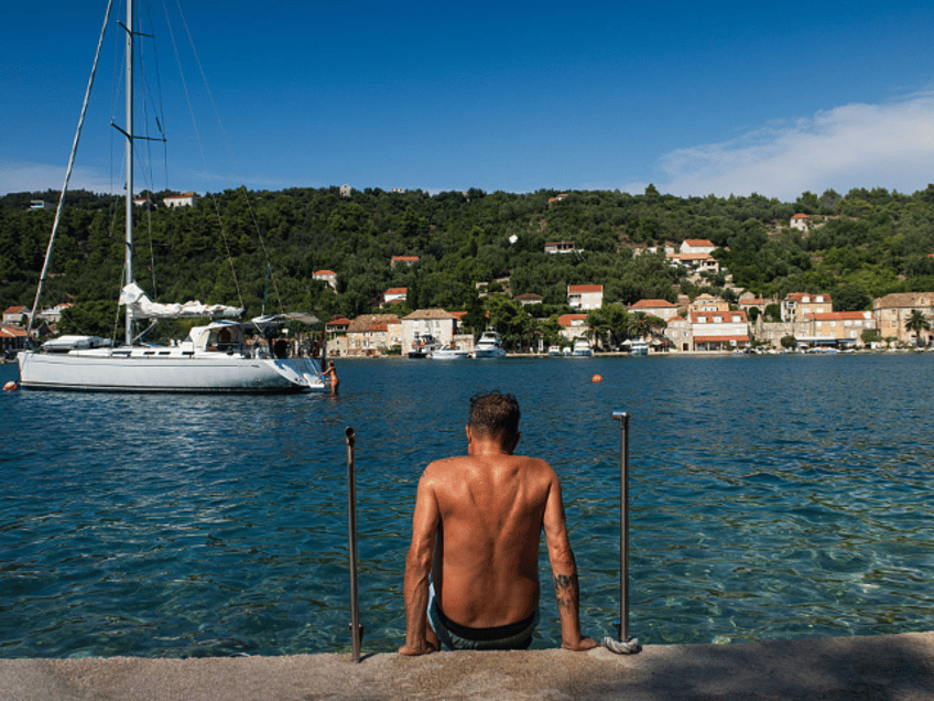 DUBROVNIK, CROATIA - JULY17: A tanned man is seen getting into the water on ipan island, t