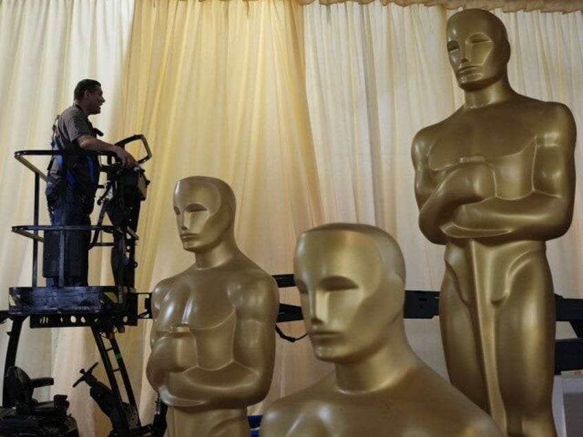 Workers prepare the red carpet area before Sunday's 97th Academy Awards in Los Angeles, Fr