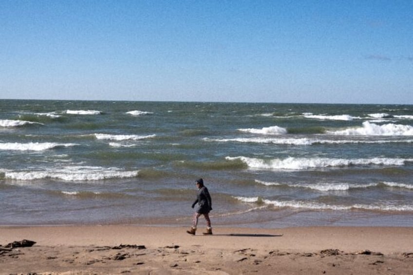 A woman walks along the Lake Michigan shoreline in February in Whiting, Indiana; the Great