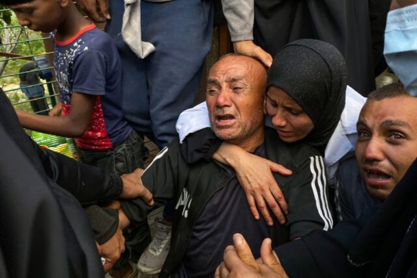 Palestinians mourn relatives killed near a US-backed aid center in the Rafah area, in the