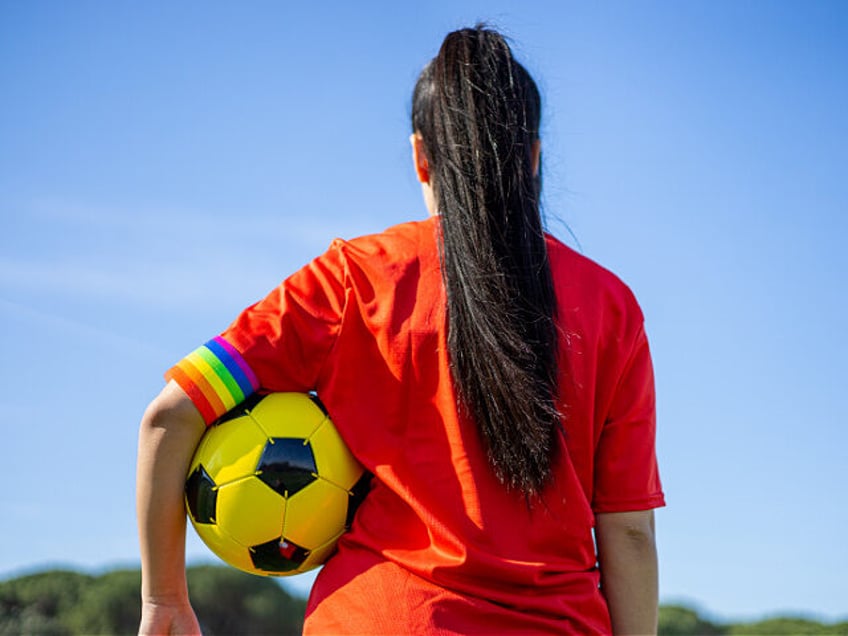 LGBT pride flag on the field. LGBTQ people in sport. - stock photo