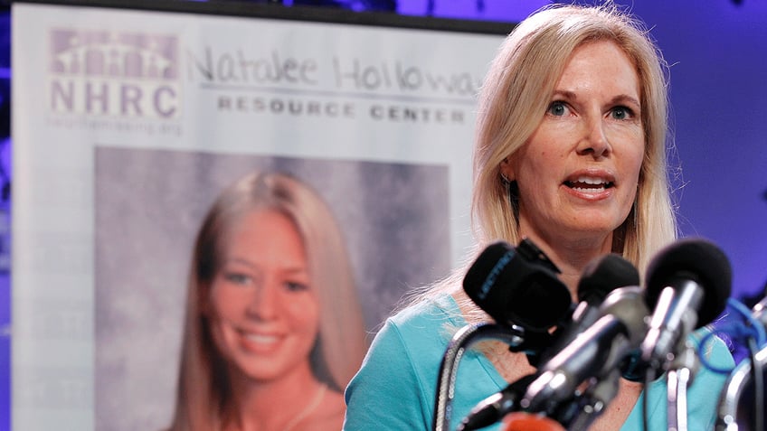 Beth Holloway speaks at a microphone