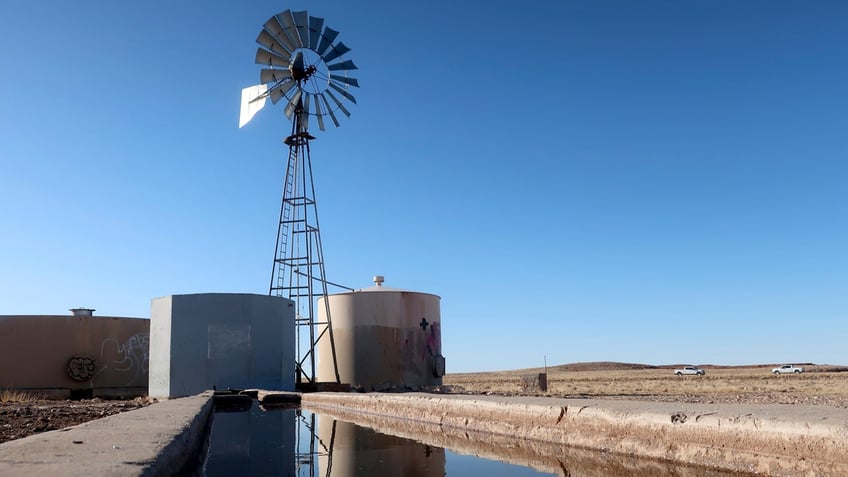 A windmill draws water for livestock