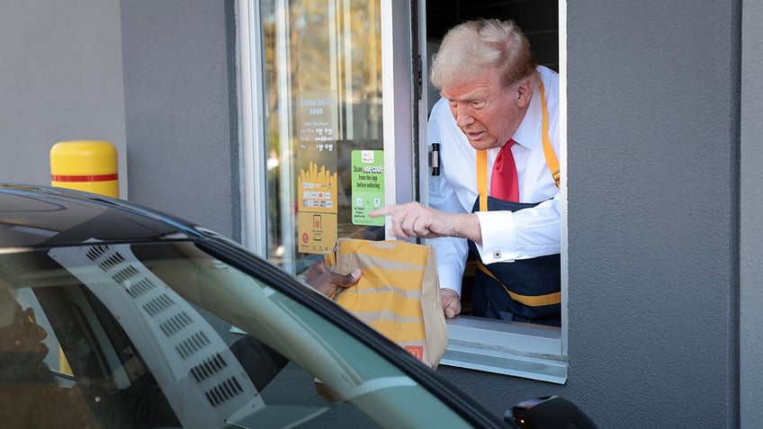 Republican presidential nominee and former President Donald Trump works the drive-through line during a campaign photo op as he visits a McDonald's restaurant