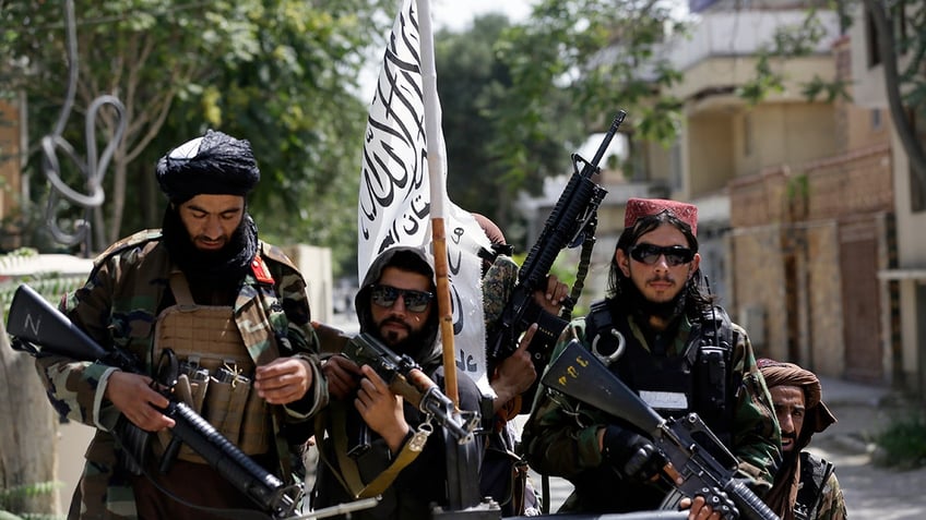 Taliban fighters display their flag while on patrol in Kabul, Afghanistan, on Aug. 19, 2021.