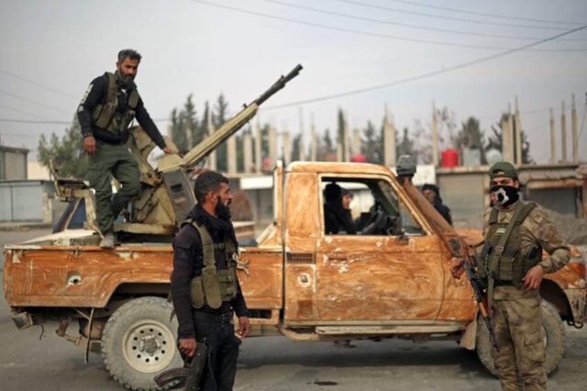 Fighters affiliated with the Turkish-backed Syrian National Army faction patrol in the Man