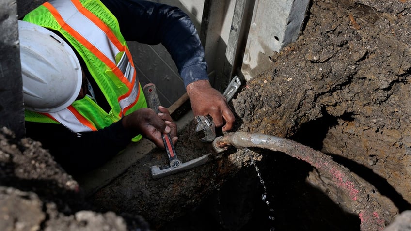 Blackhawk Sewer and Water contractor Khaild Waarith fixes a leaking lead service pipe ahead of service line replacement