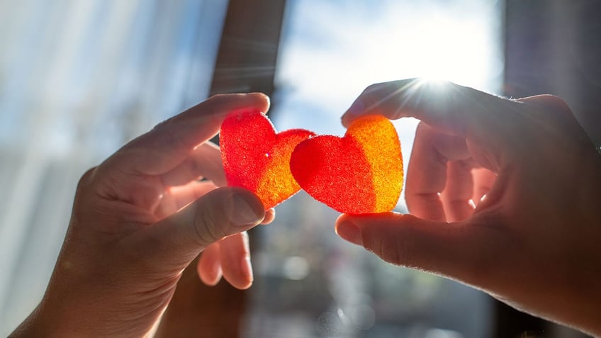 heart-shaped sweets in hands.