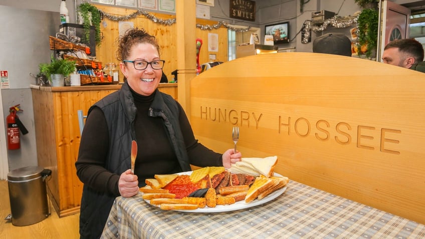 Shelaine Crabtree, owner of the Hungry Hossee, poses with the "Big One" breakfast plate.