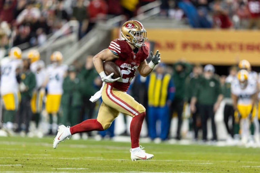 Christian McCaffrey of the San Francisco 49ers runs with the ball for a touchdown during an NFL divisional round playoff football game between the...