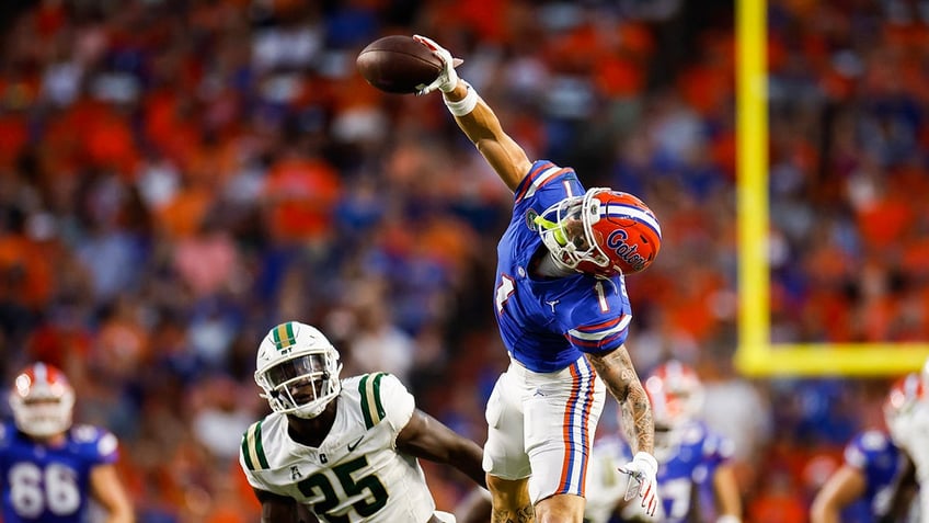 Ricky Pearsall #1 of the Florida Gators catches a pass against Prince Bemah #25 of the Charlotte 49ers during the first halfof a game at Ben Hill Griffin Stadium on September 23, 2023 in Gainesville, Florida. 