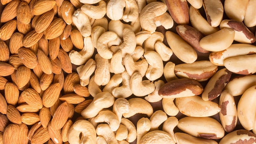 Almond, cashew and Para nuts heart shaped in white background.