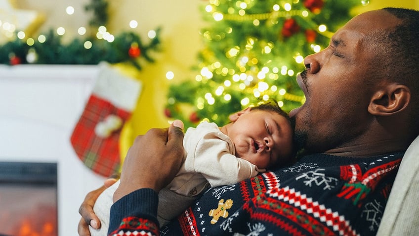 Father with baby taking a nap during Christmas