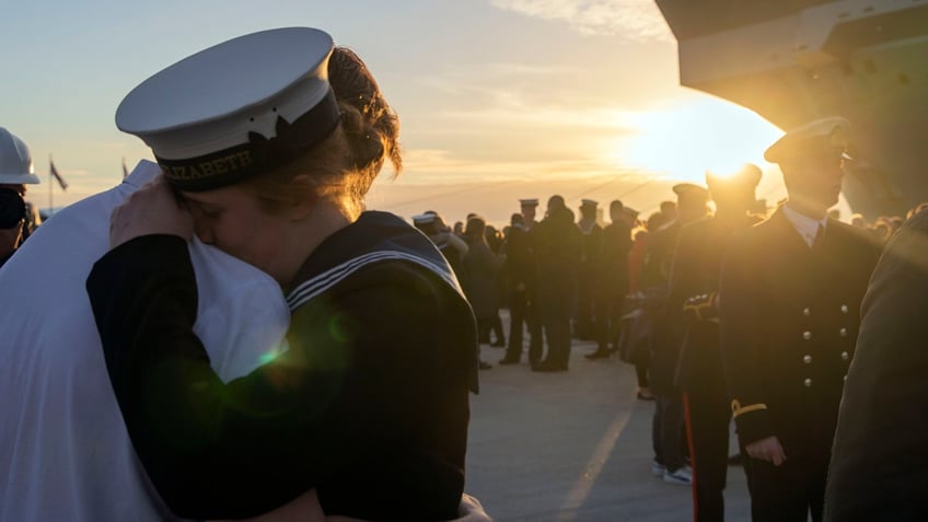 Military woman hugs man after returning home