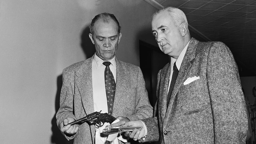 Detectives examining a gun and knife.