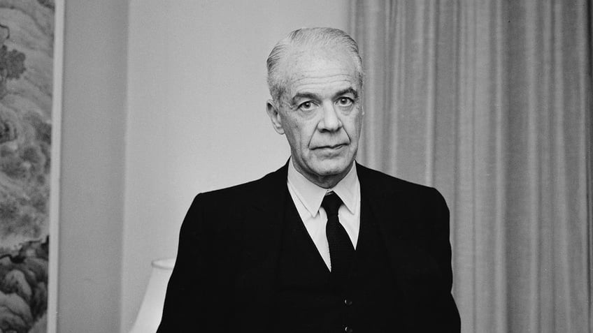 A somber looking Walter Wanger in a black suit