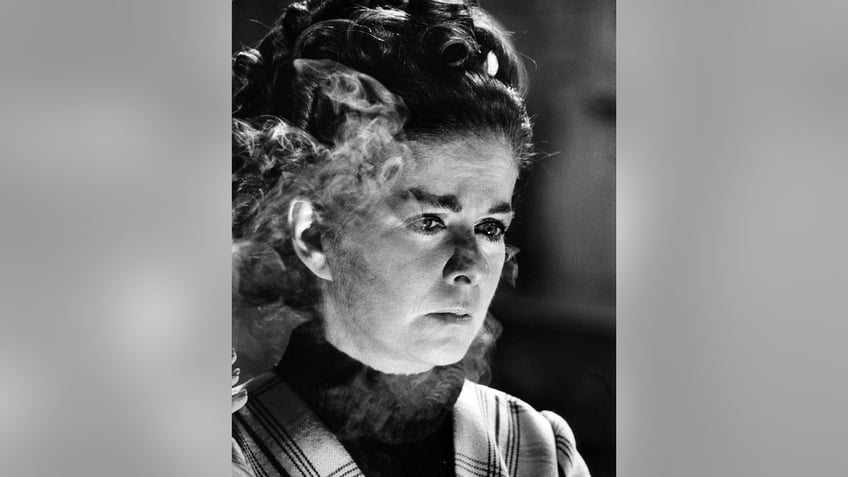 A close-up of Joan Bennett surrounded by smoke.