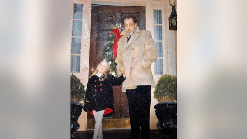 Victoria Price standing in front of her home with her dad at Christmas time