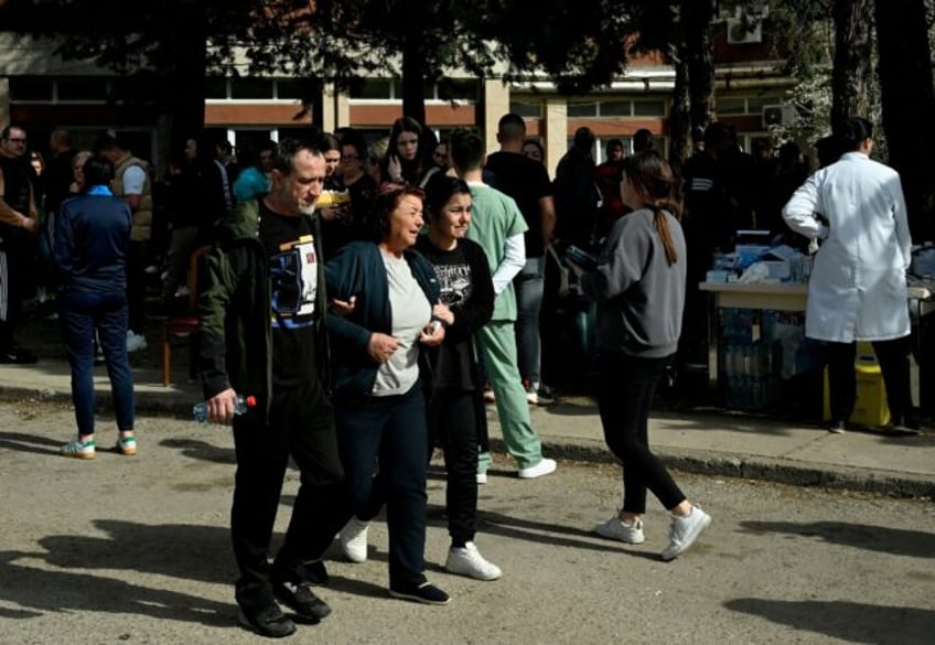 Friends and relatives of the victims gather in front of a hospital following a fire in a n