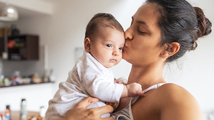 Mom kissing baby's head