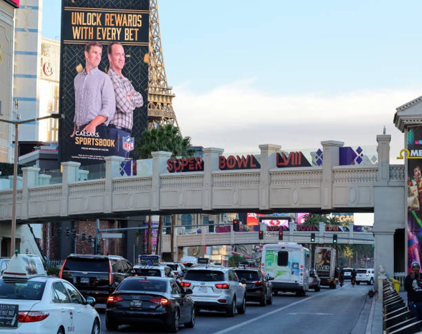 Signage for Super Bowl LVIII is displayed on a pedestrian bridge on the Las Vegas Strip as an advertisement featuring former NFL players Eli Manning...