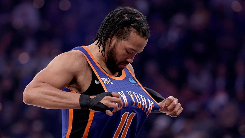 Jalen Brunson looks down at Knicks jersey