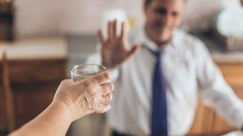 man refuses a drink