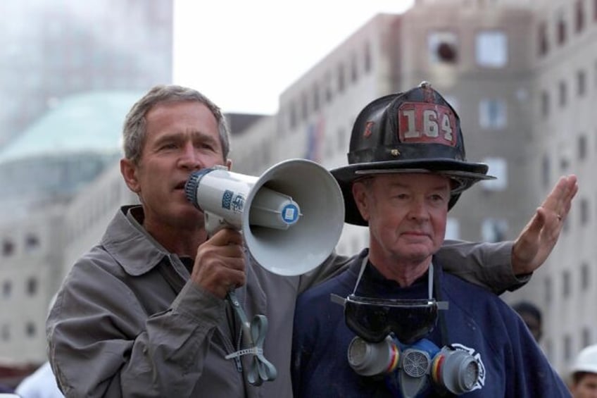 President Bush speaks atop the ruins of the Twin Towers following the September 11, 2001 terrorist attacks, with retired firefighter Bob Beckwith by his side