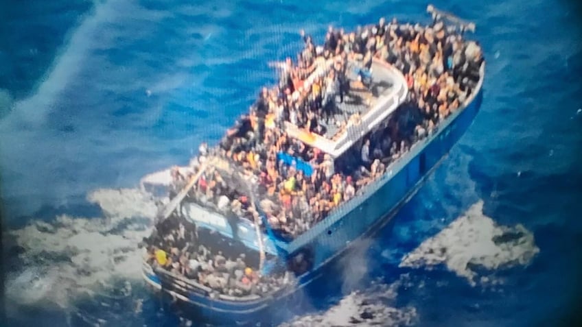 In this undated handout provided by Greece's coast guard, scores of people sit on a battered fishing boat that later capsized and sank off southern Greece.