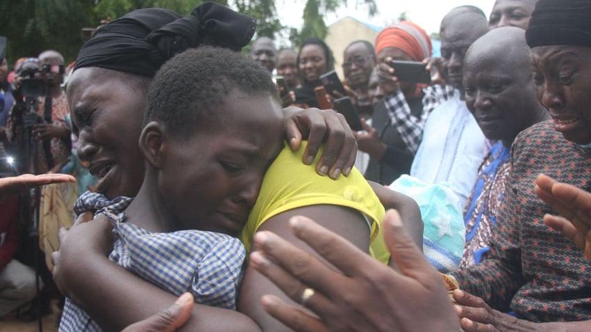 A mother hugs her daughter after she was released together with 27 students of the Bethel Baptist High School after they were kidnapped by armed gunmen.