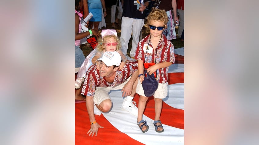 Luke Perry on the red and white target carpet with his two children