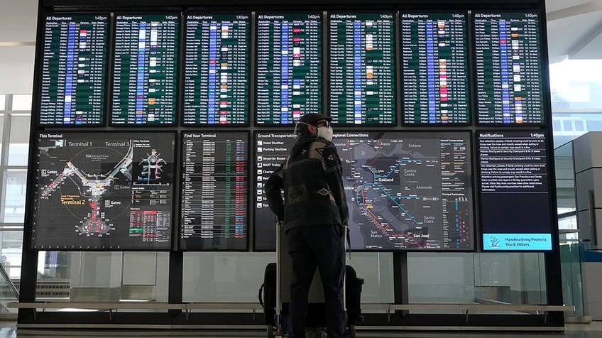 Woman looks at flight information board