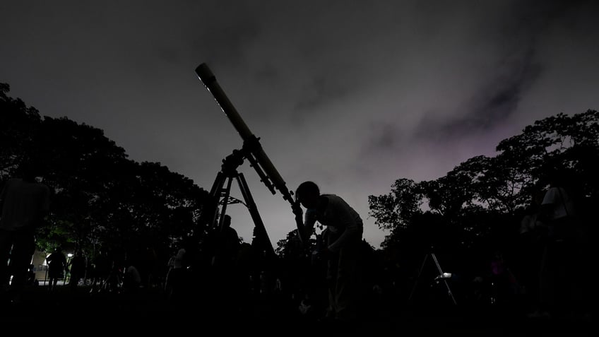 Girl looks through telescope