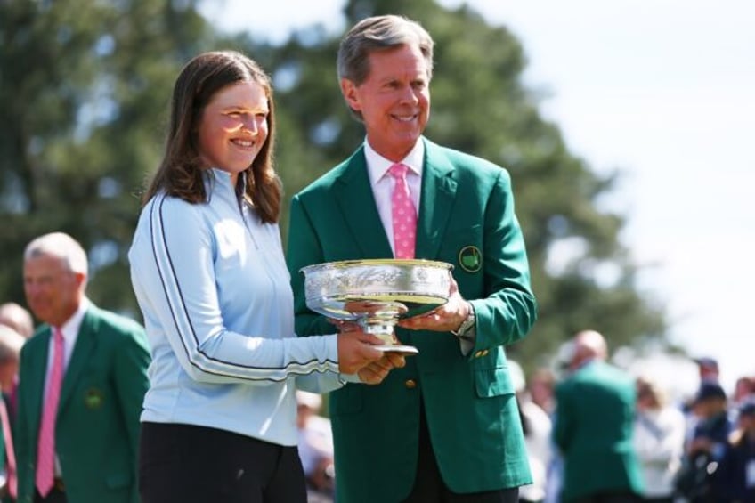 Augusta National chairman Fred Ridley presents Lottie Woad of England with the trophy foll