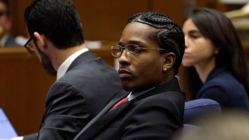 Rapper A$AP Rocky wears glasses and suit in court.