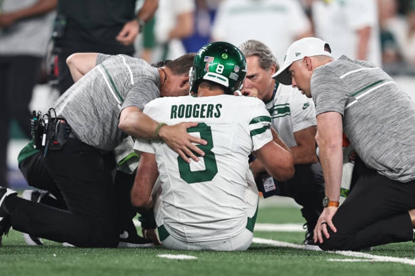 Aaron Rodgers of the New York Jets is looked at by the medical staff on the field for an apparent injury during a game against the Buffalo Bills at...