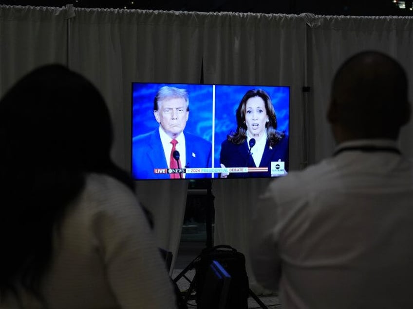 Staff watch a presidential debate between Republican presidential nominee former President