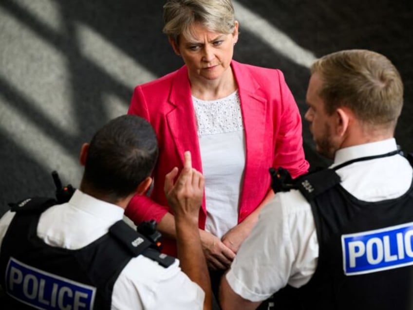 Britain's Home Secretary Yvette Cooper speaks with police officers who were on duty o