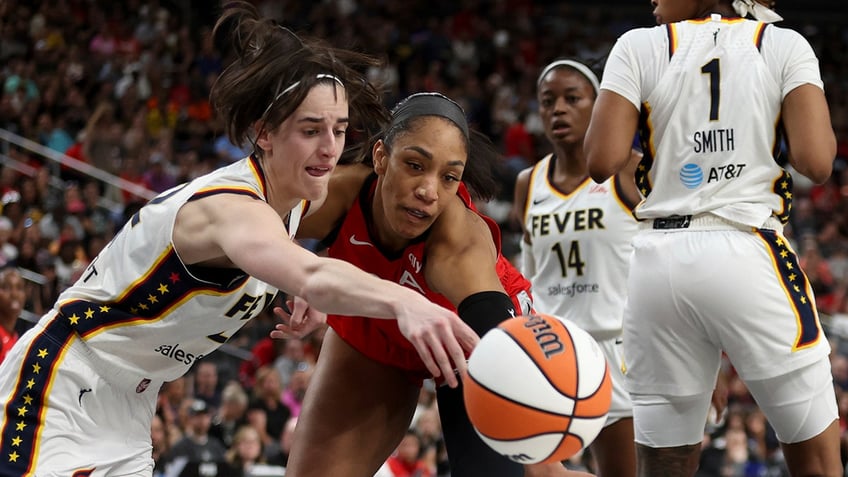 Caitlin Clark and A'ja Wilson battle for loose ball