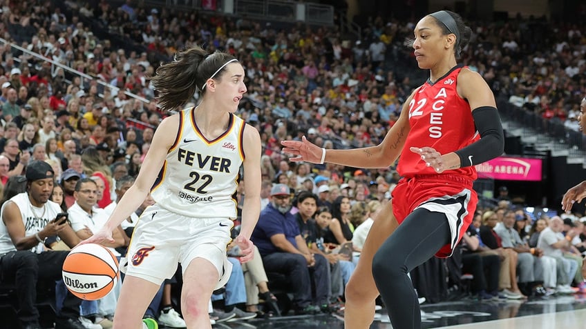 Caitlin Clark dribbles by A'ja Wilson