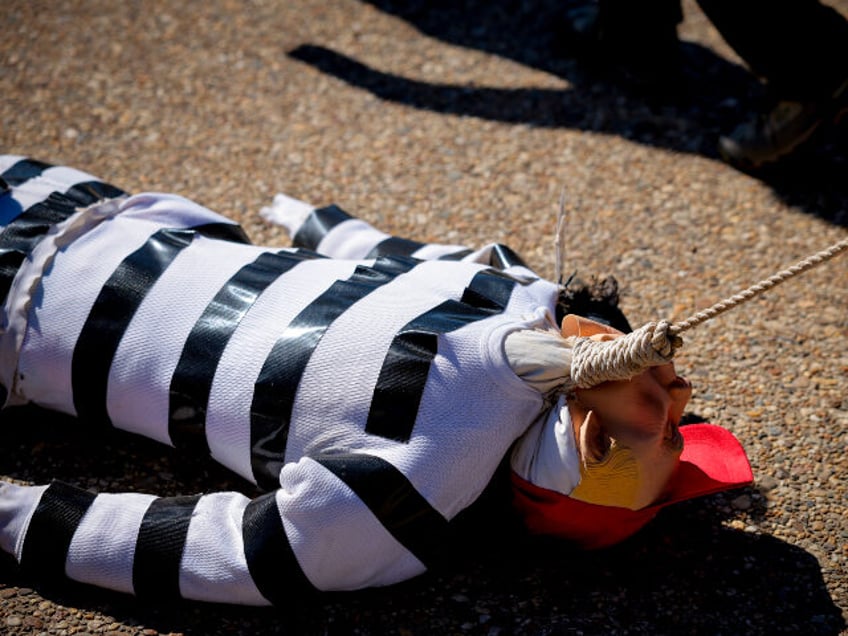 WASHINGTON, DC - FEBRUARY 17: A man drags a fake body by a rope at a rally against the Tru