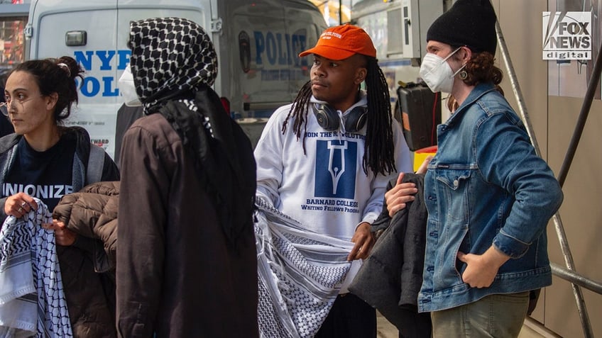 Anti-Israel agitators block bystanders’ views as protesters are placed into the back of a police vehicle