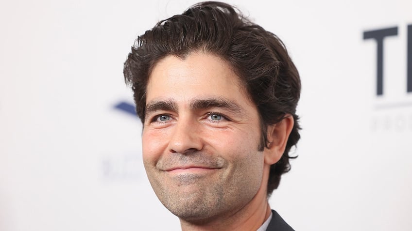 Adrian Grenier soft smiles on the carpet